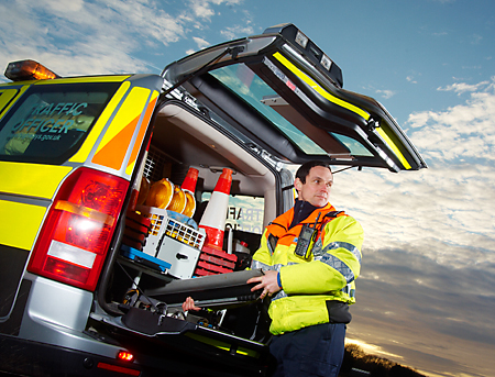 Traffic Officer unpacks equipment from his vehicle whilst keeping a watchful eye on the oncoming traffic